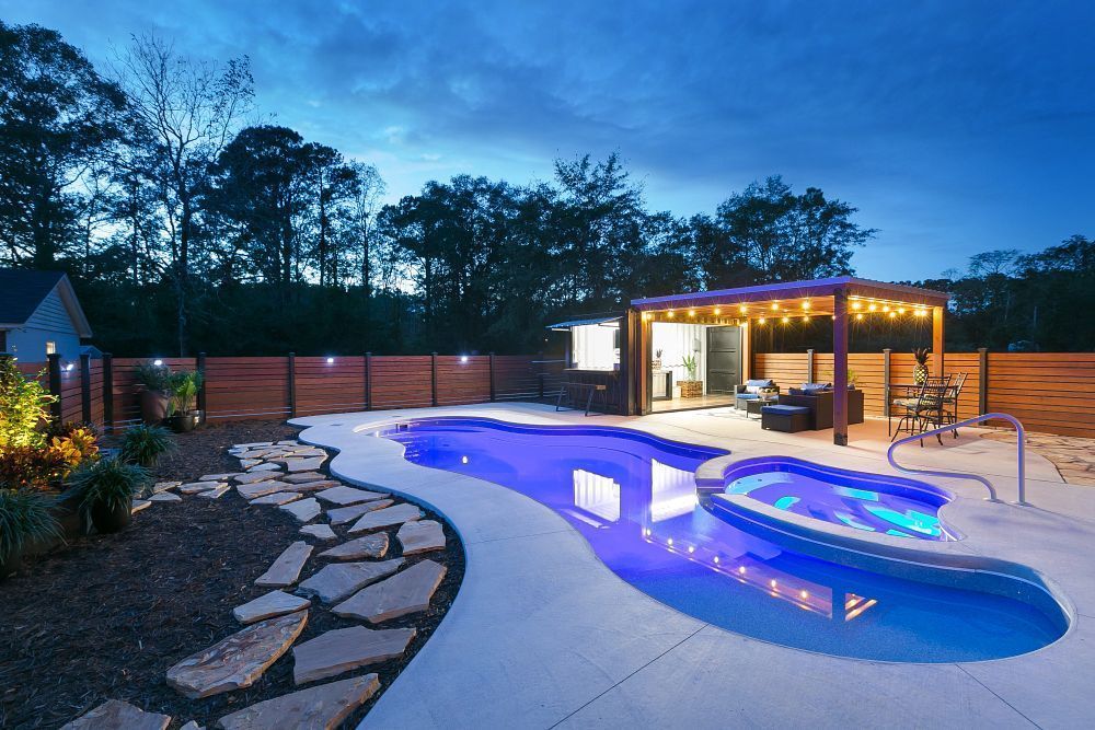 A pool and spa lit up at dusk